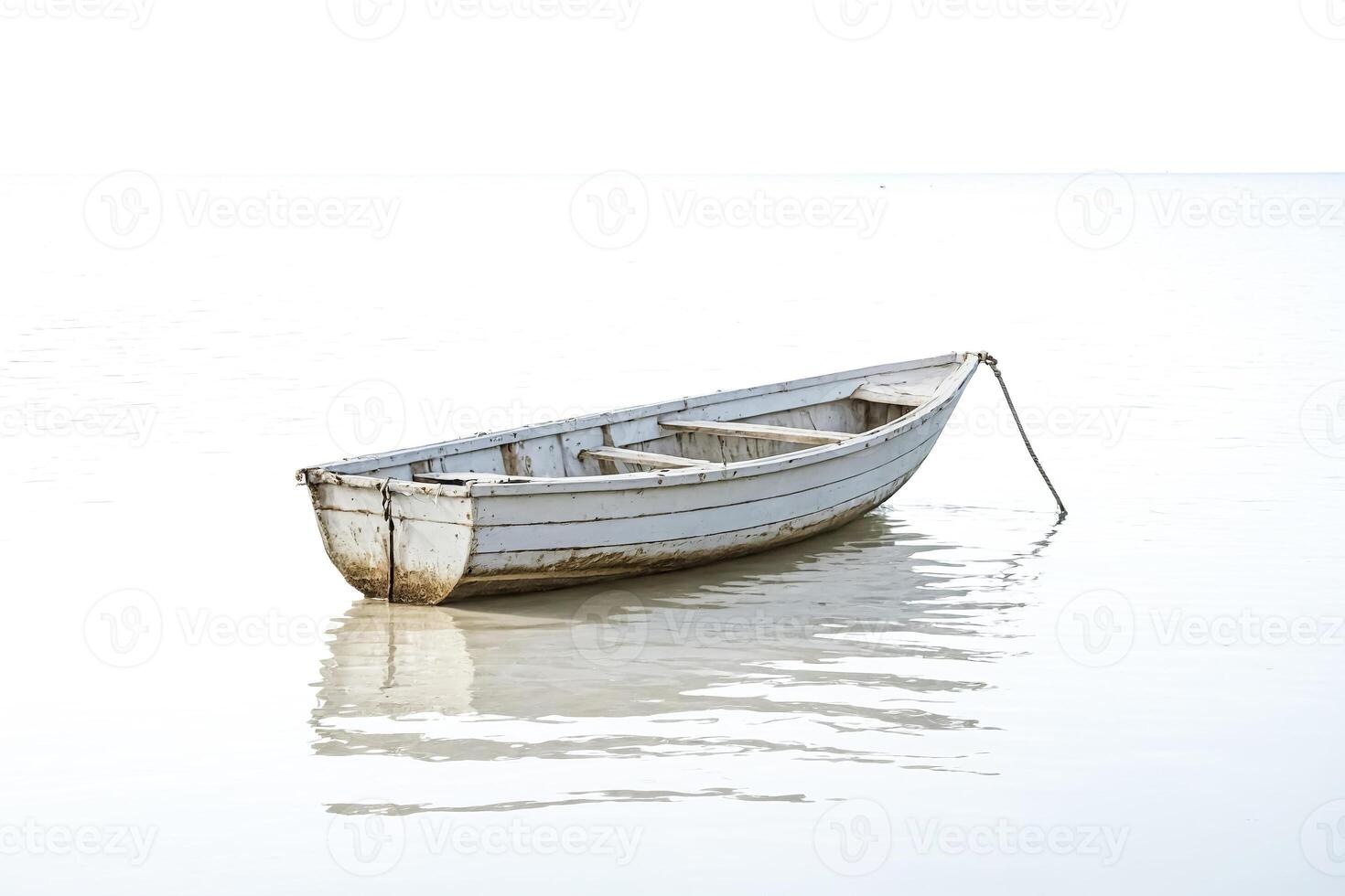 Small white boat floating on calm water photo