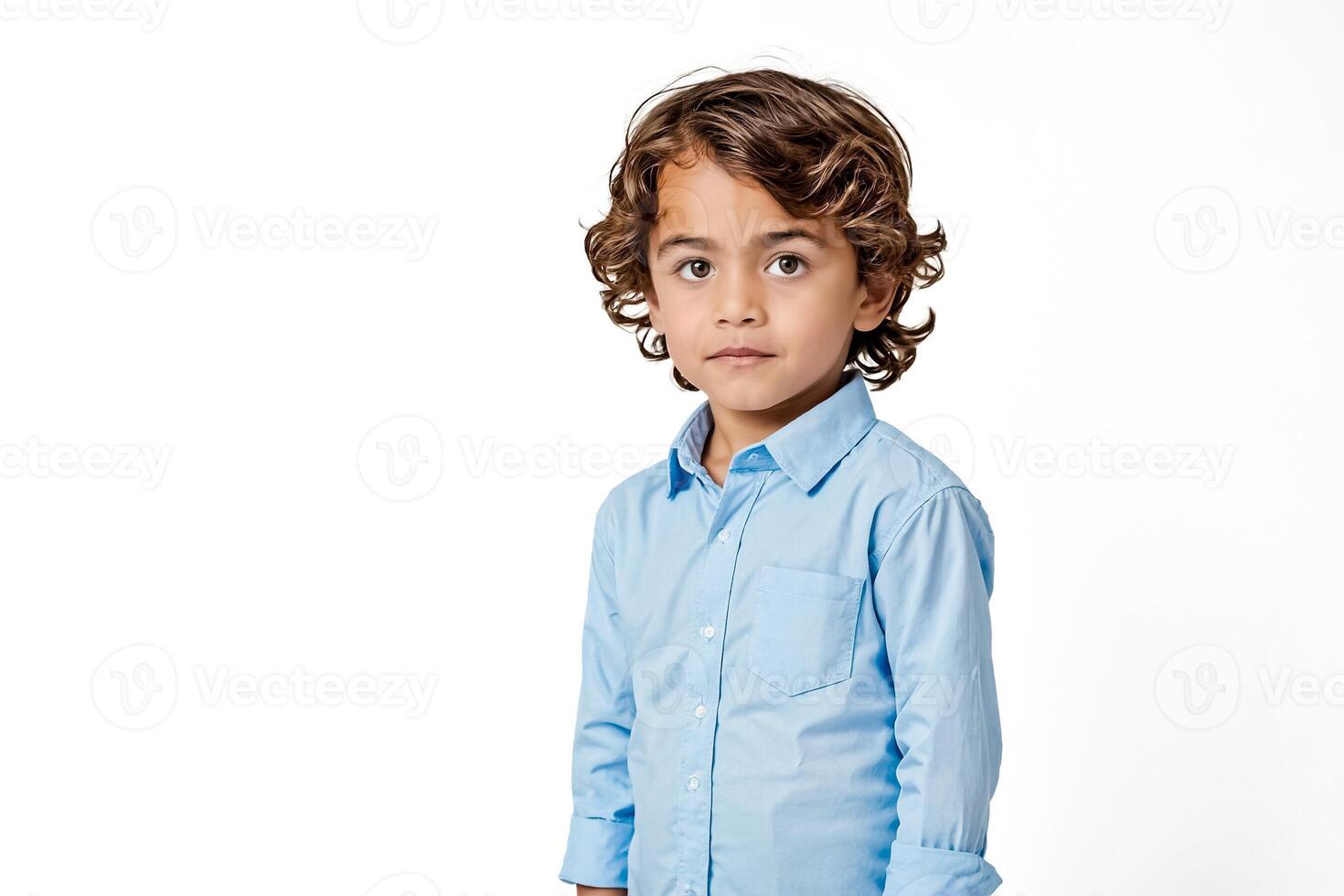 Young Boy Wearing a Blue Shirt Looking Thoughtfully at the Camera photo