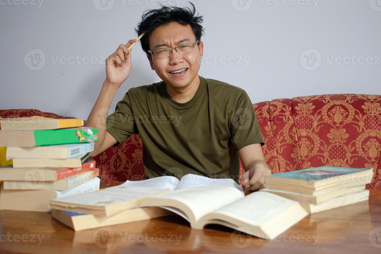 Asian young male reading book with frustrated gesture. Asian male with glasses confused face with Isolated white background photo