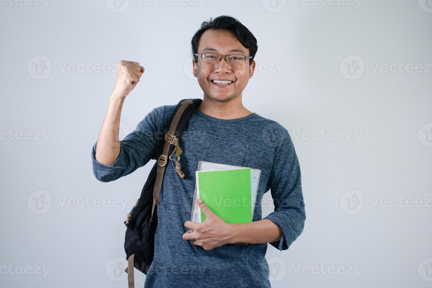 Asian student holding books and making strong gesture with Isolated white background photo