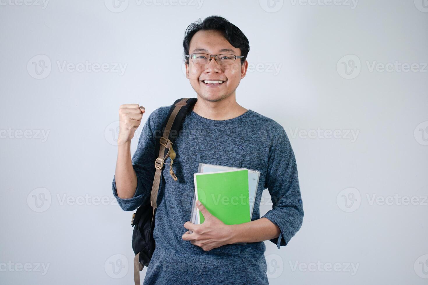 Asian student holding books and making strong gesture with Isolated white background photo