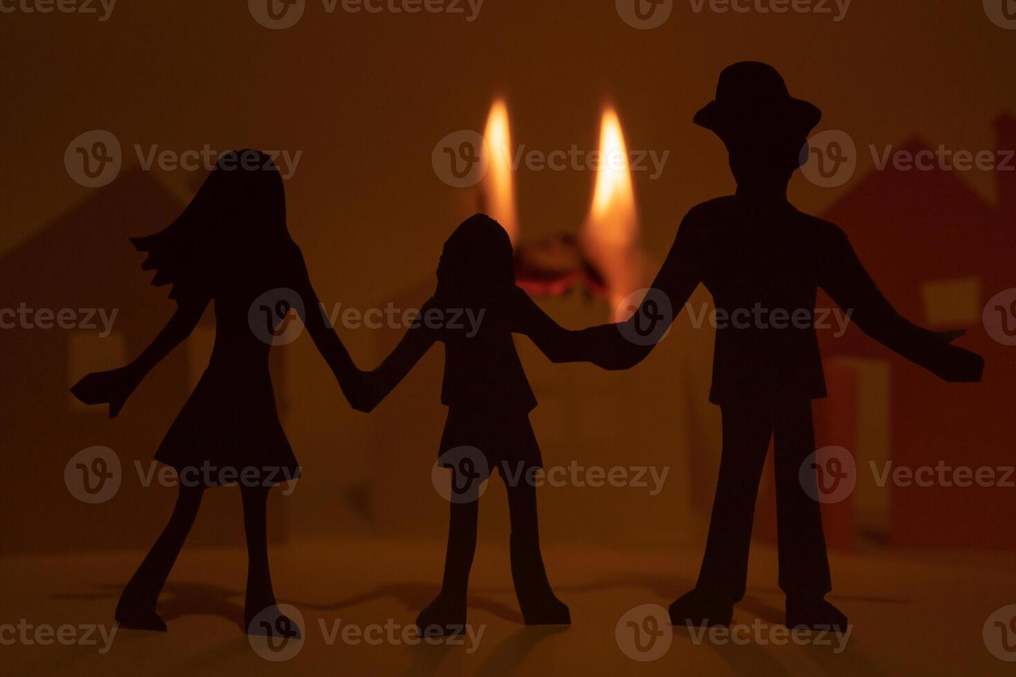 Cut from the paper family on the background of a burning paper house. photo
