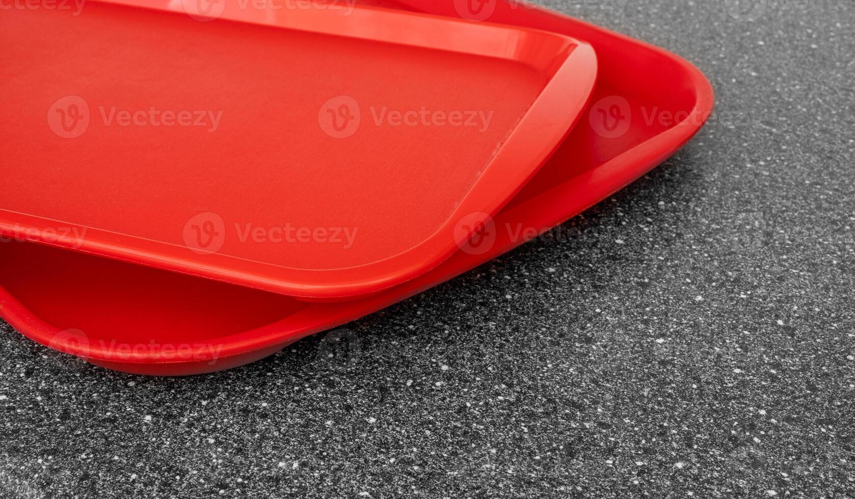 Empty red plastic trays on a black kitchen table. photo