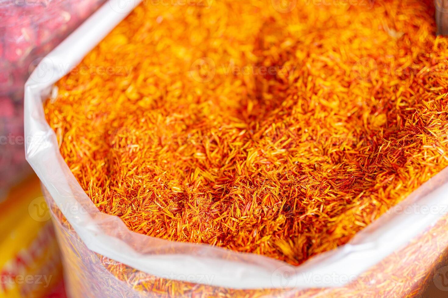 A bag of orange spice is shown in a white plastic bag photo
