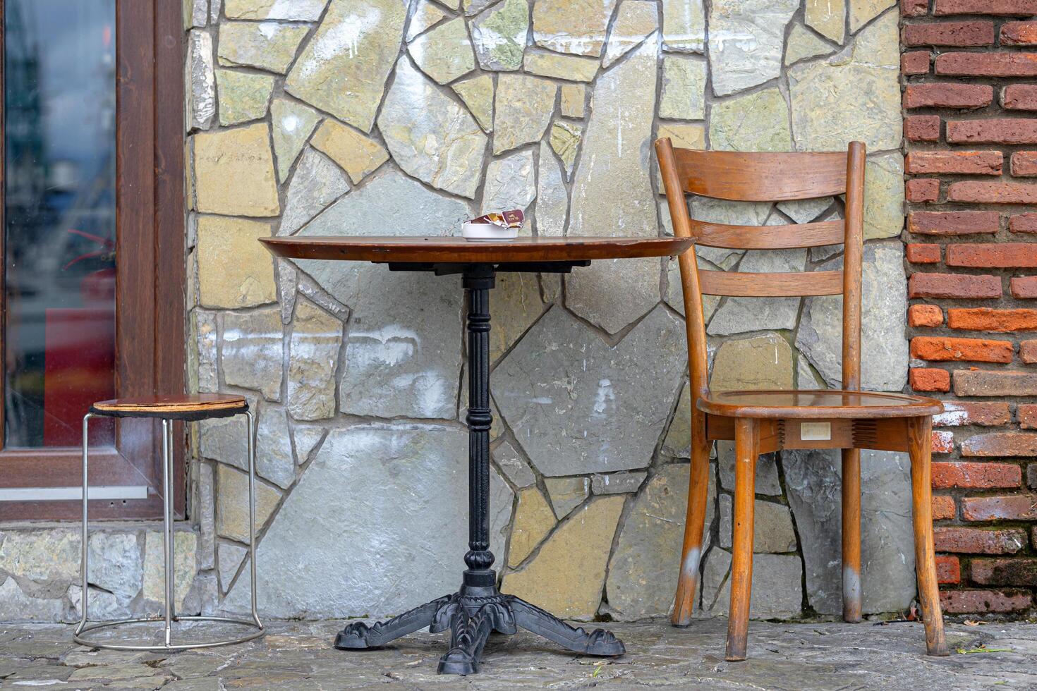 Old chair and old table near stone wall. Retro style. photo