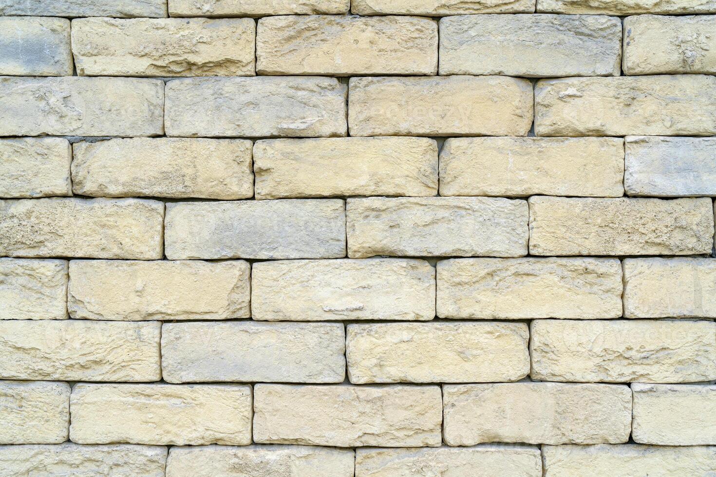 Texture of yellow brick made of sandstone and limestone. The wall of the house. photo