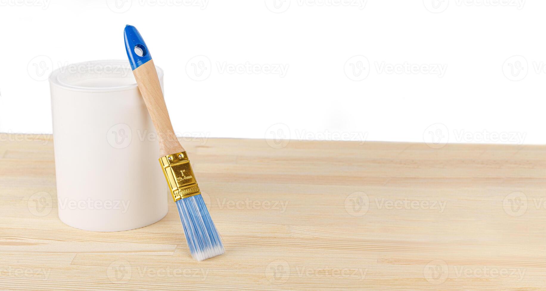 white paint with a brush on a wooden background with texture photo
