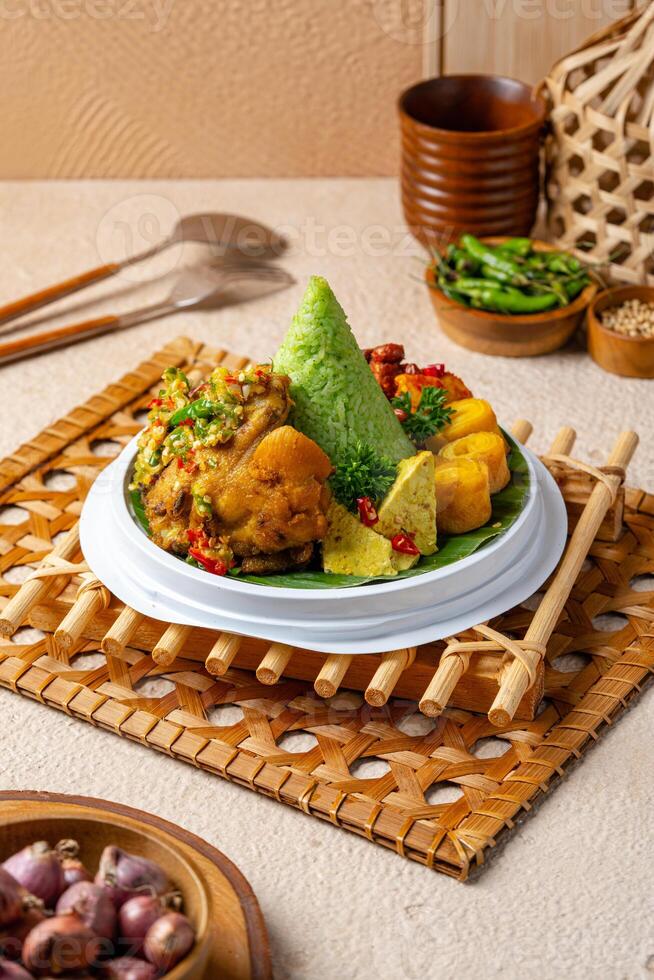 Tumpeng is an Indonesian cone-shaped rice dish with side dishes of vegetables and meat originating from Javanese cuisine of Indonesia. photo