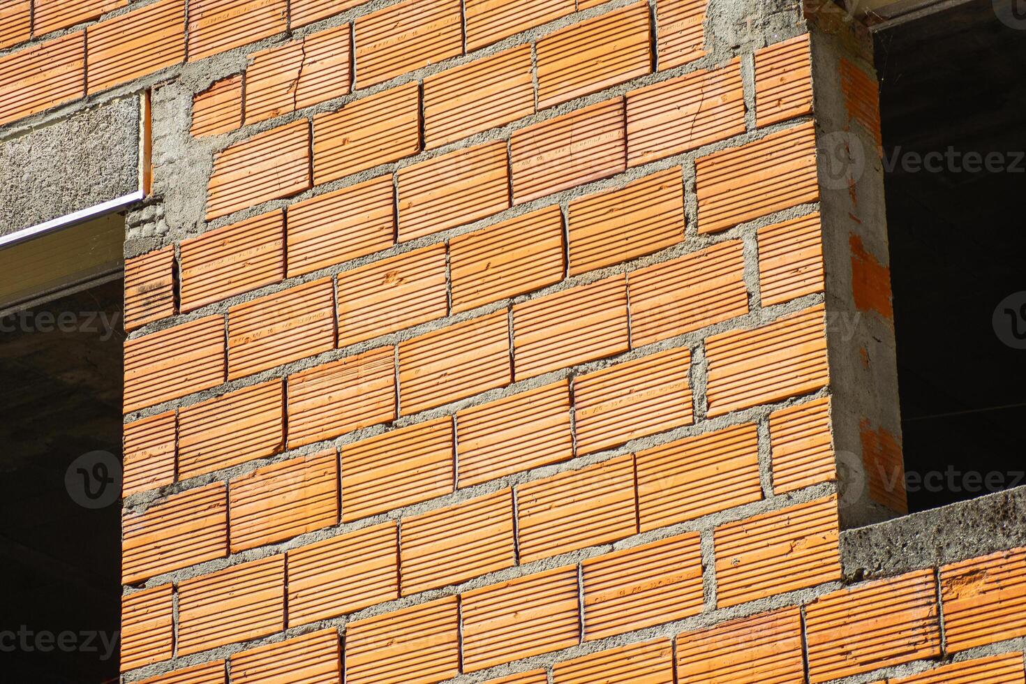 partial view of the facade of a brick and cement building under construction photo