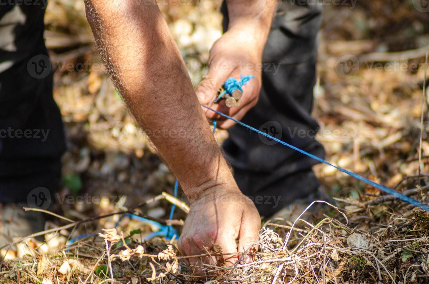 hands of an archaeologist marking the limits of the excavation with a string. Archeology concept photo