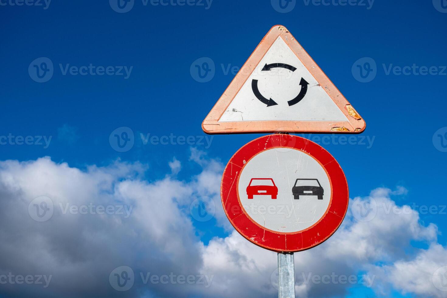 two traffic signs, one for roundabout warning and the other one for no pass signs photo