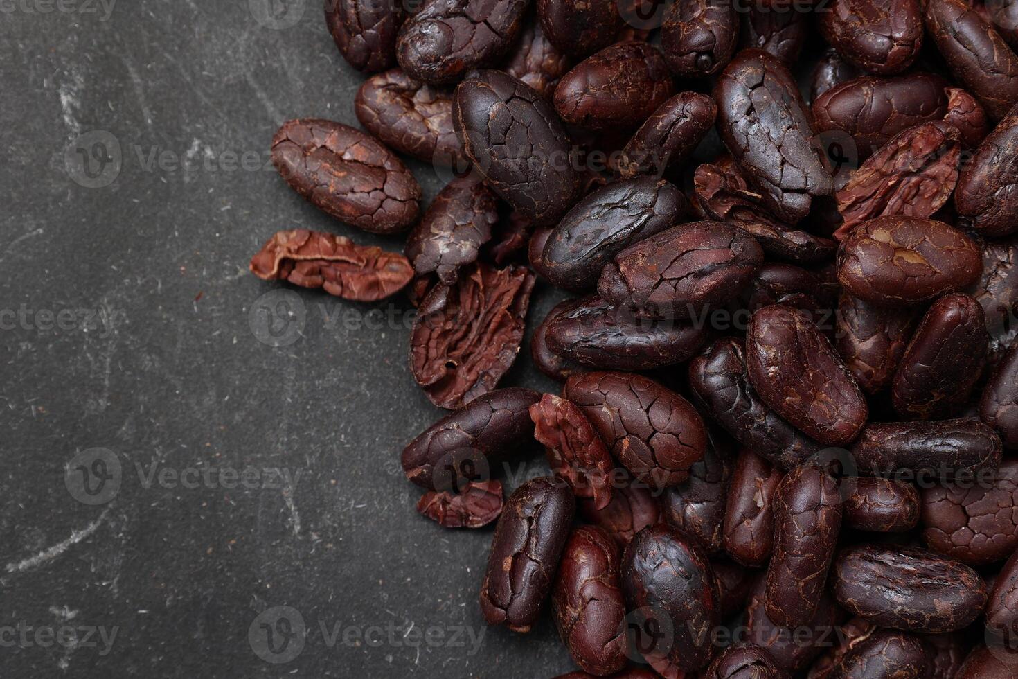 Cocoa beans on black table background photo