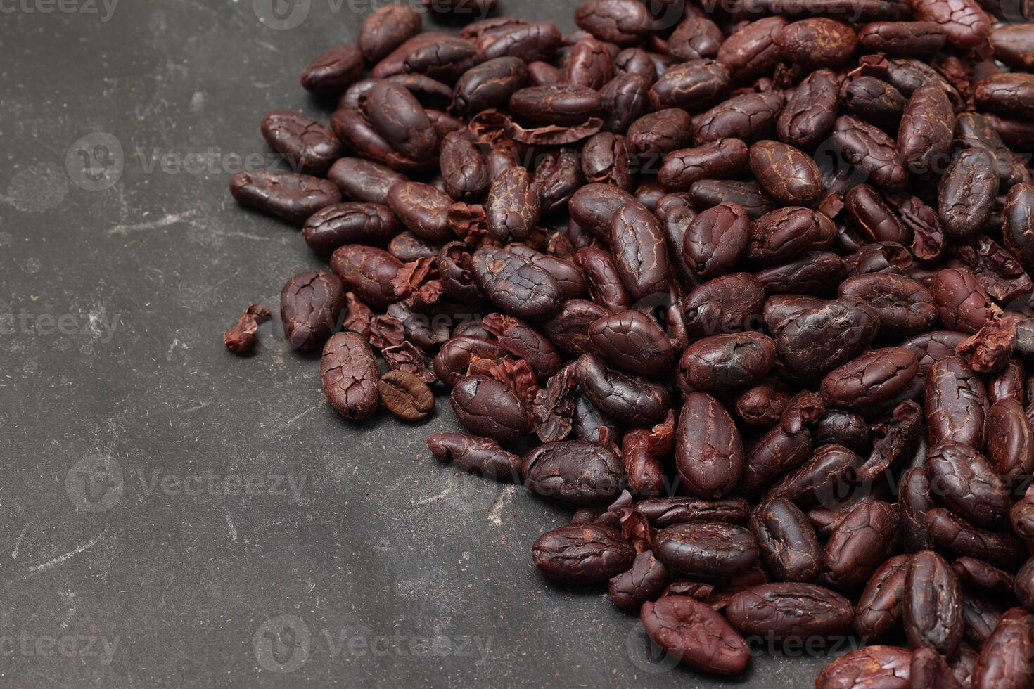 Cocoa beans on black table background photo