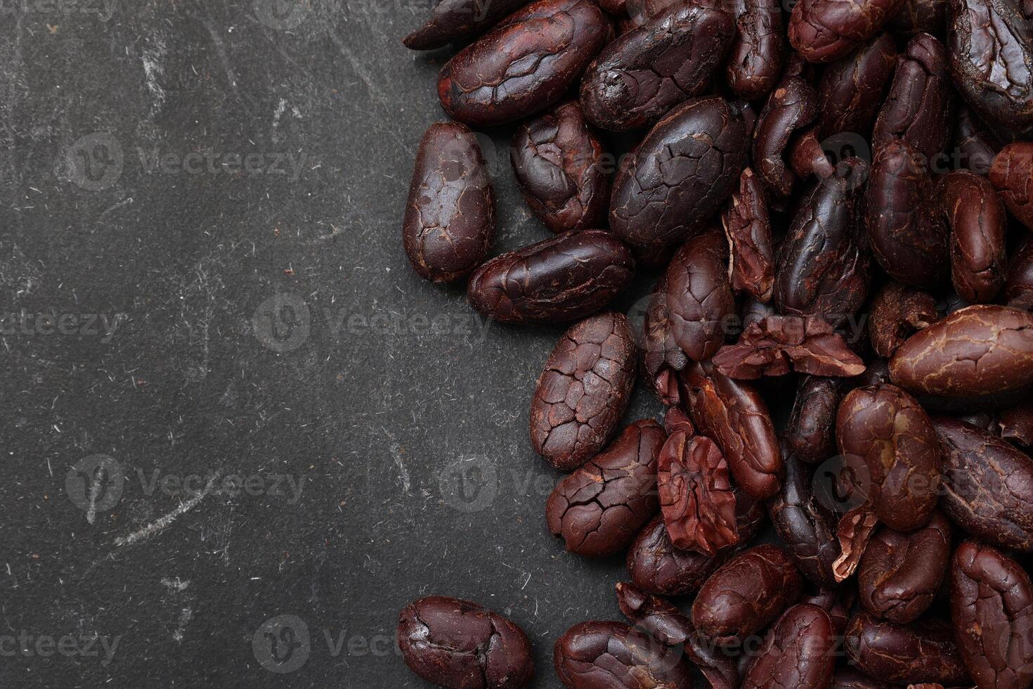Cocoa beans on black table background photo