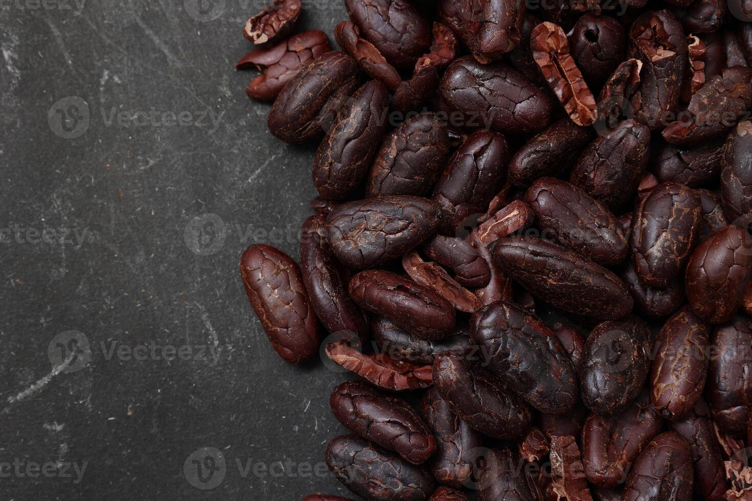 Cocoa beans on black table background photo