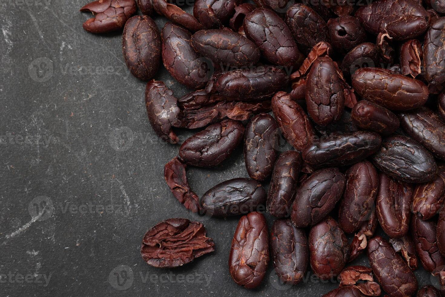 Cocoa beans on black table background photo