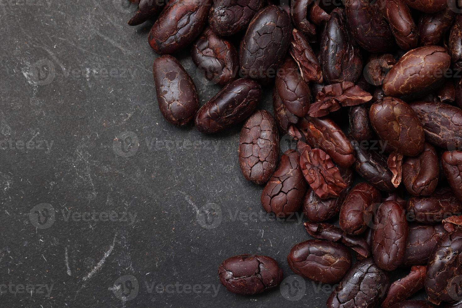 Cocoa beans on black table background photo
