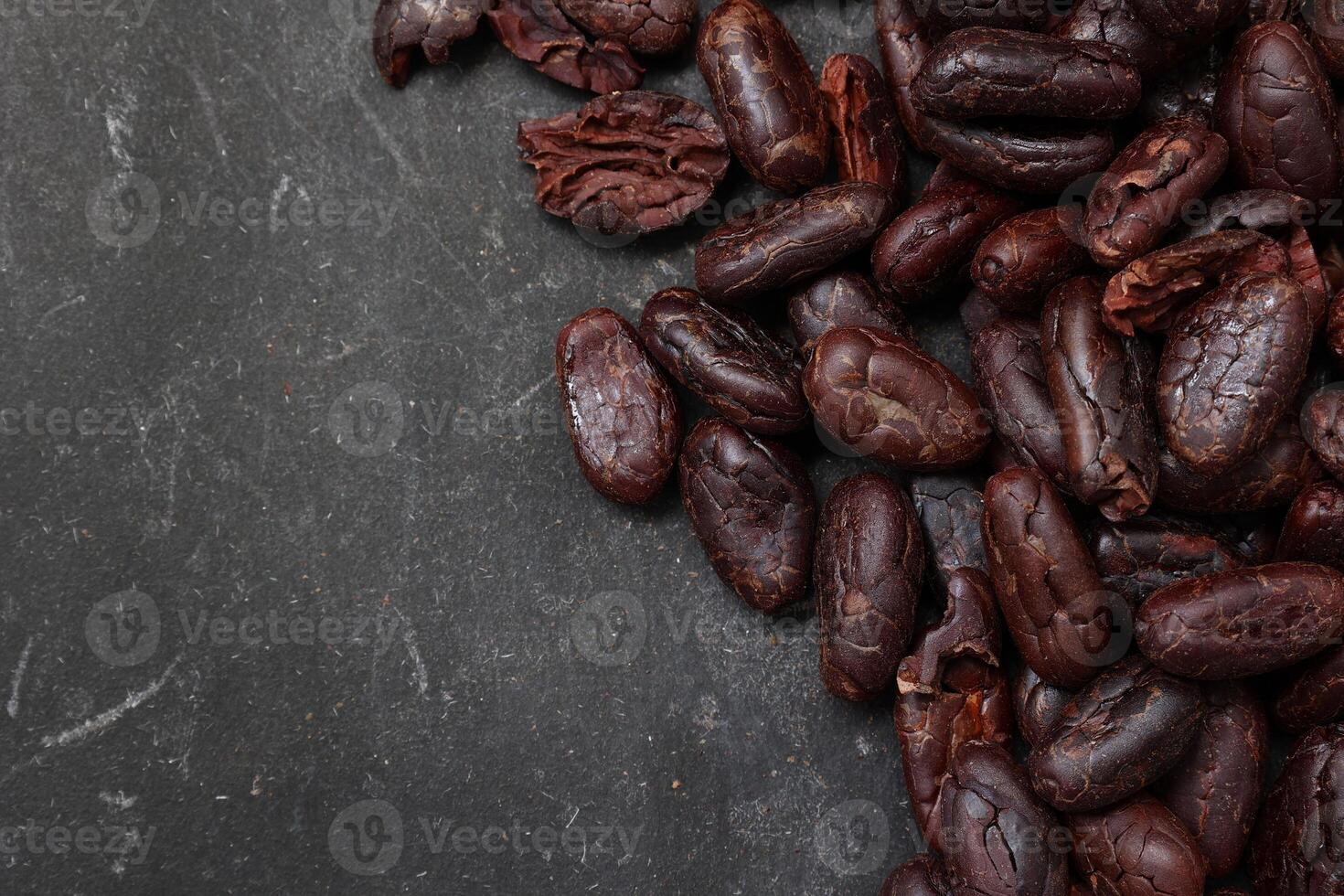 Cocoa beans on black table background photo