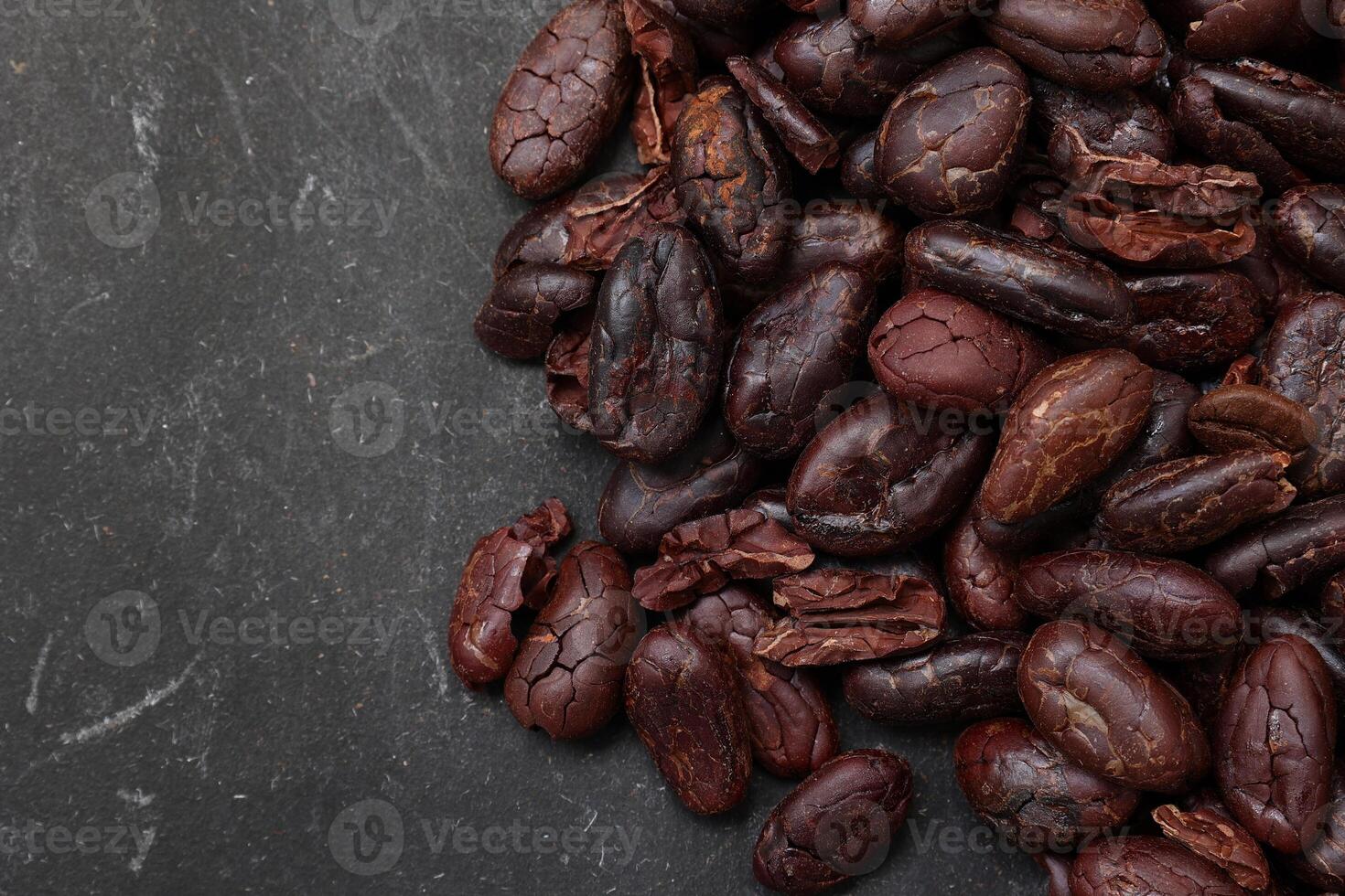 Cocoa beans on black table background photo