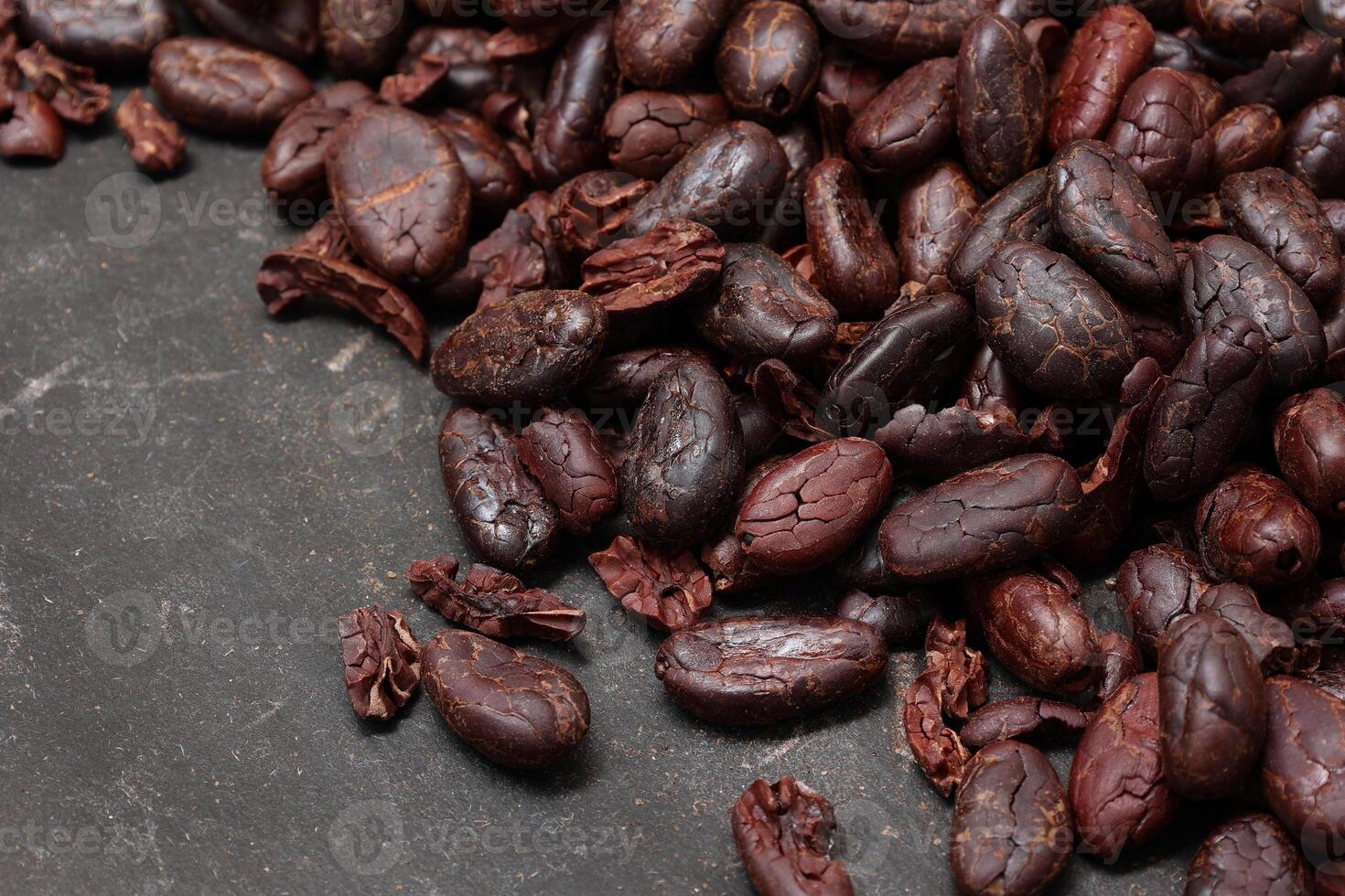 Cocoa beans on black table background photo