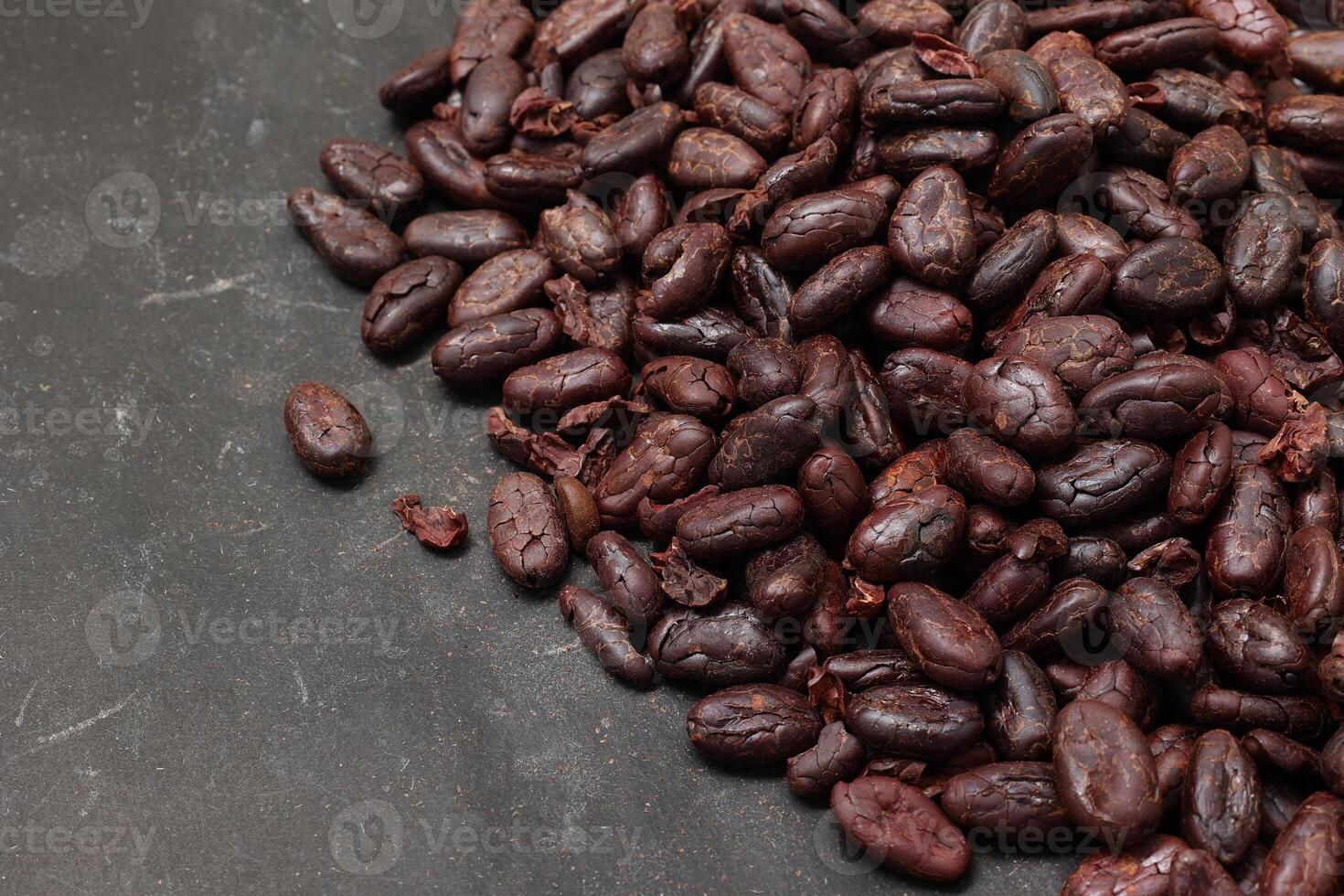 Cocoa beans on black table background photo