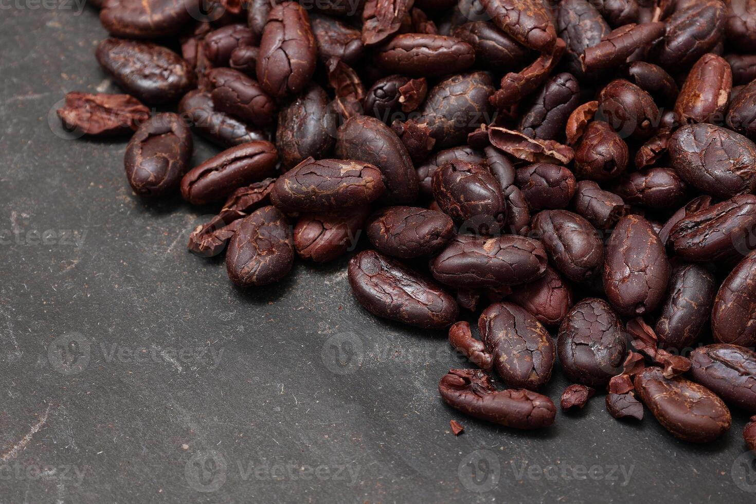 Cocoa beans on black table background photo