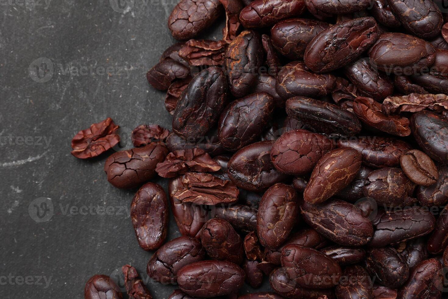 Cocoa beans on black table background photo