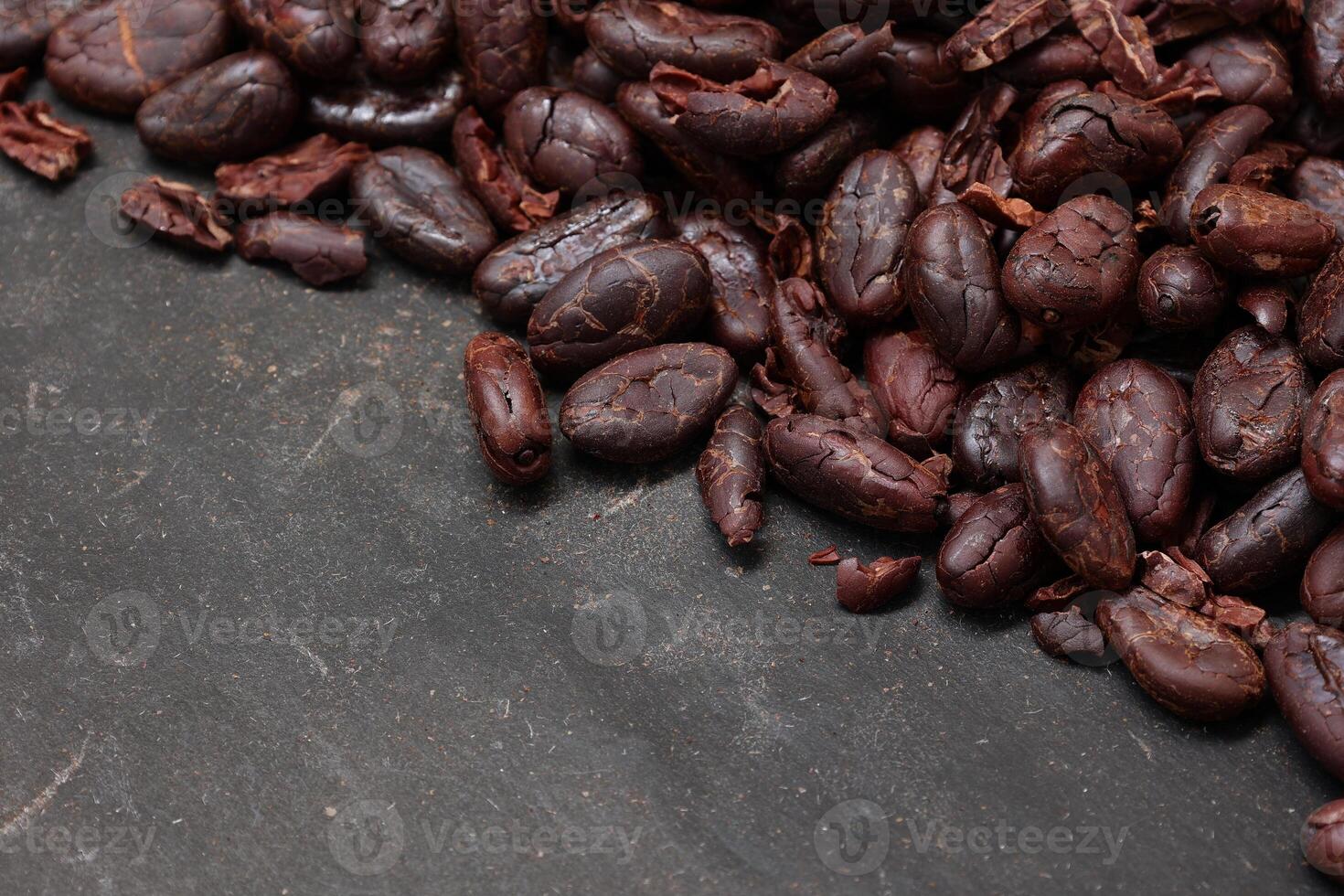 Cocoa beans on black table background photo