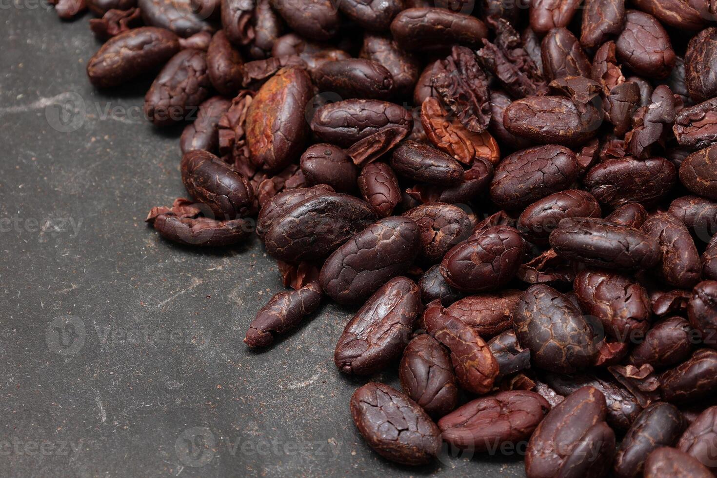 Cocoa beans on black table background photo
