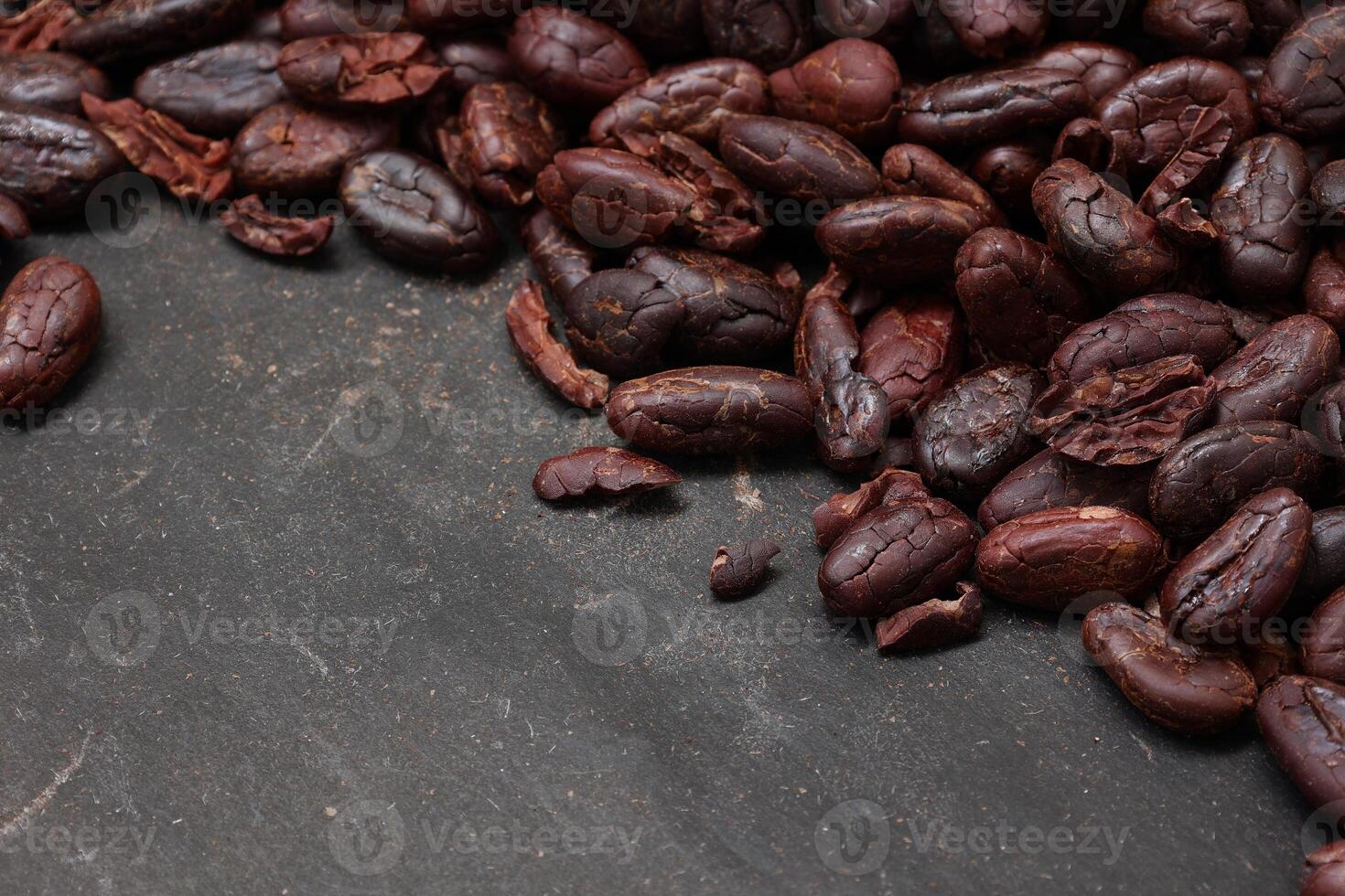 Cocoa beans on black table background photo
