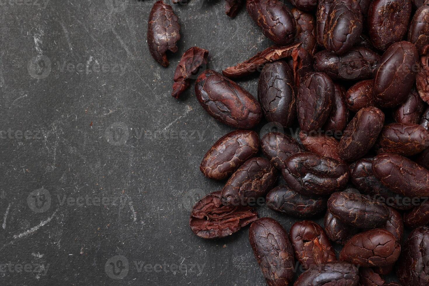 Cocoa beans on black table background photo