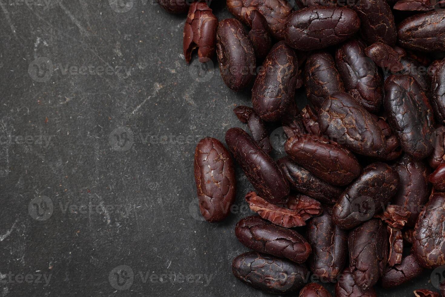 Cocoa beans on black table background photo