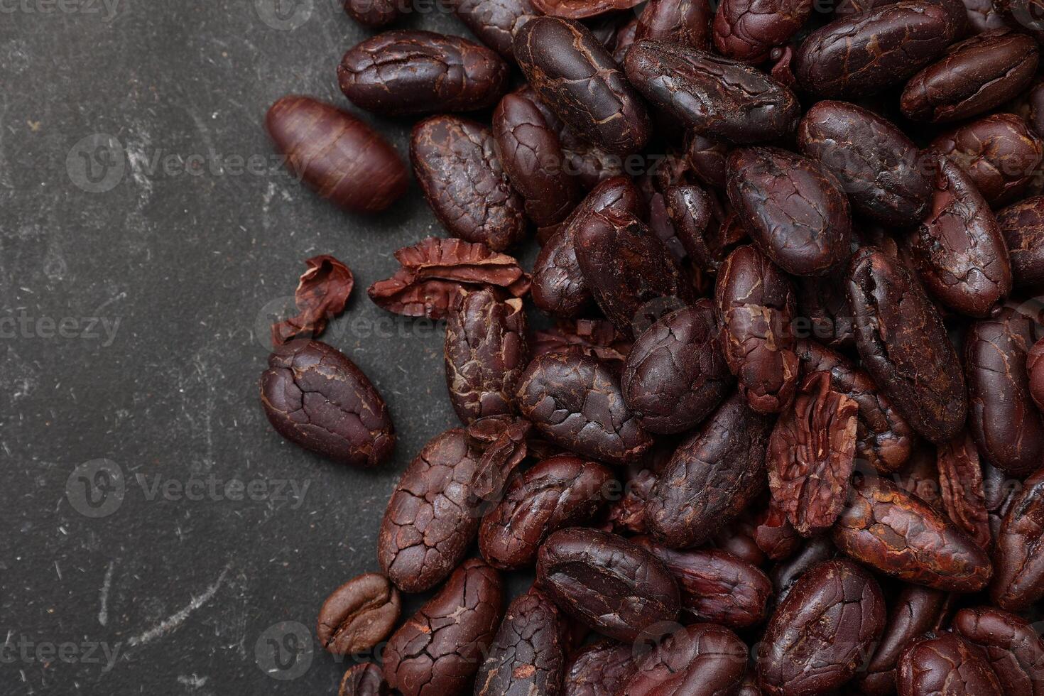 Cocoa beans on black table background photo