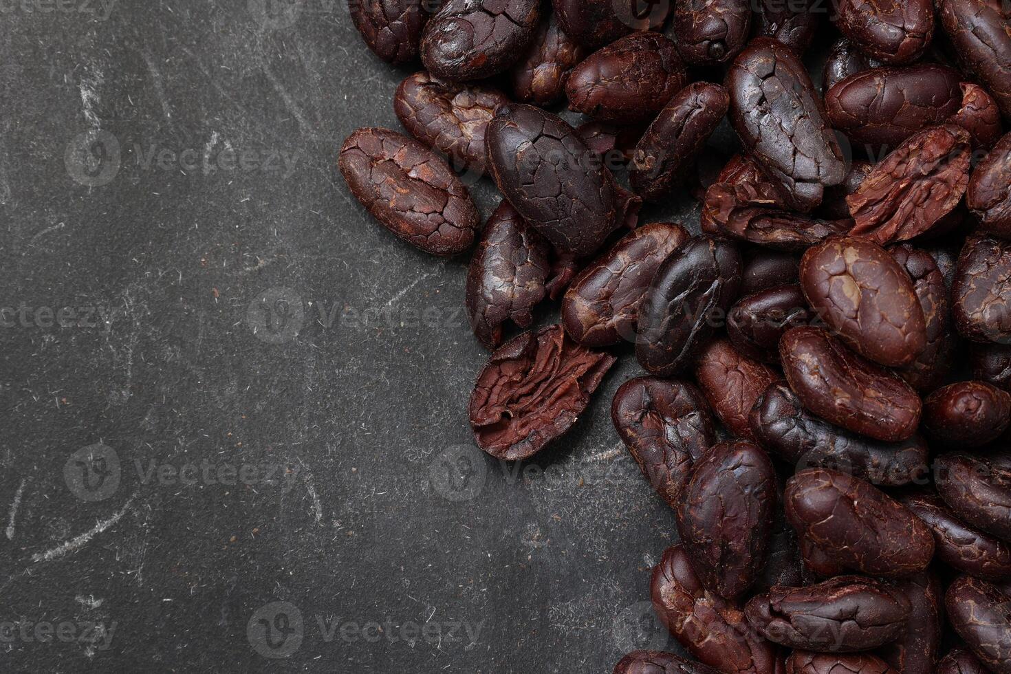 Cocoa beans on black table background photo