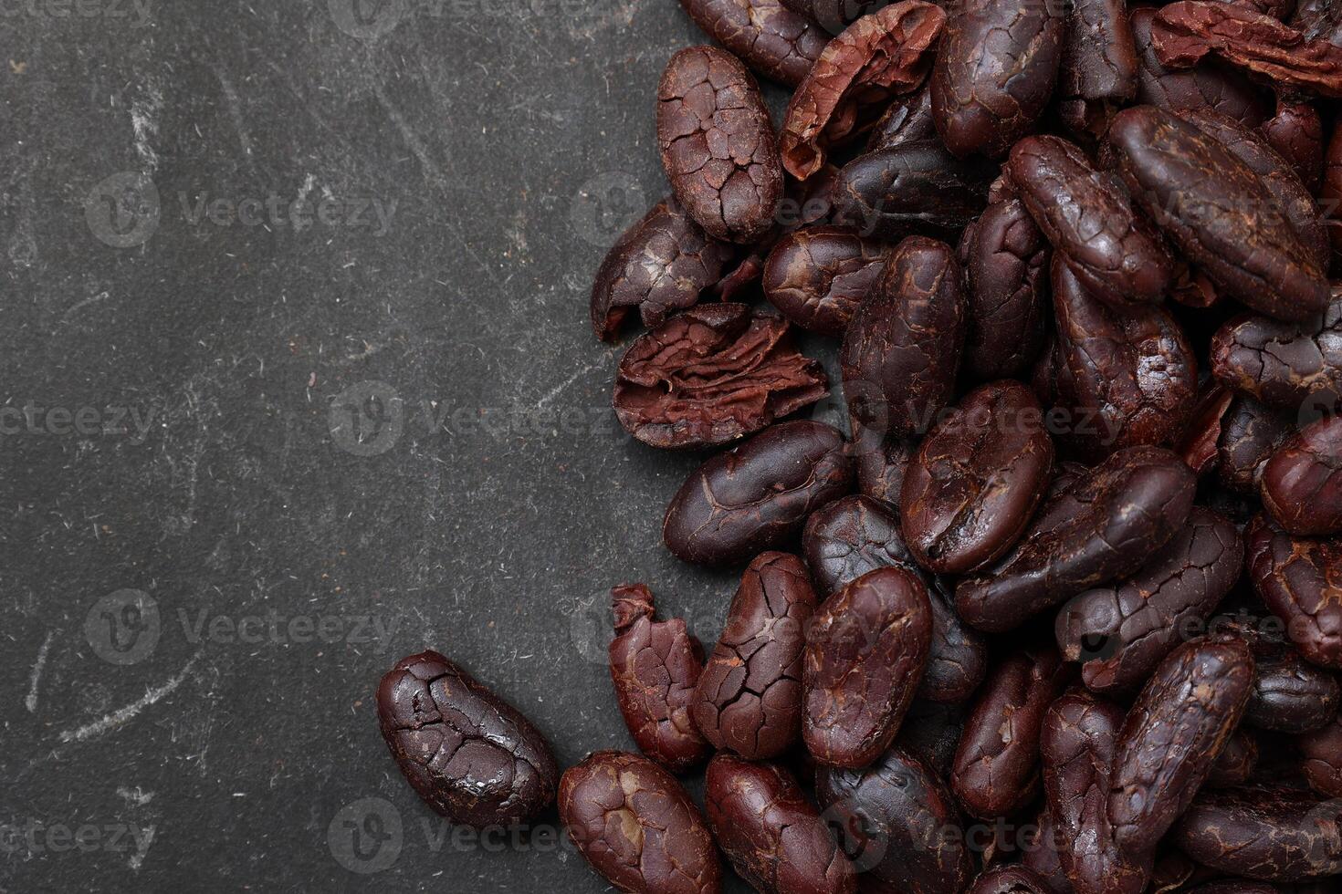 Cocoa beans on black table background photo