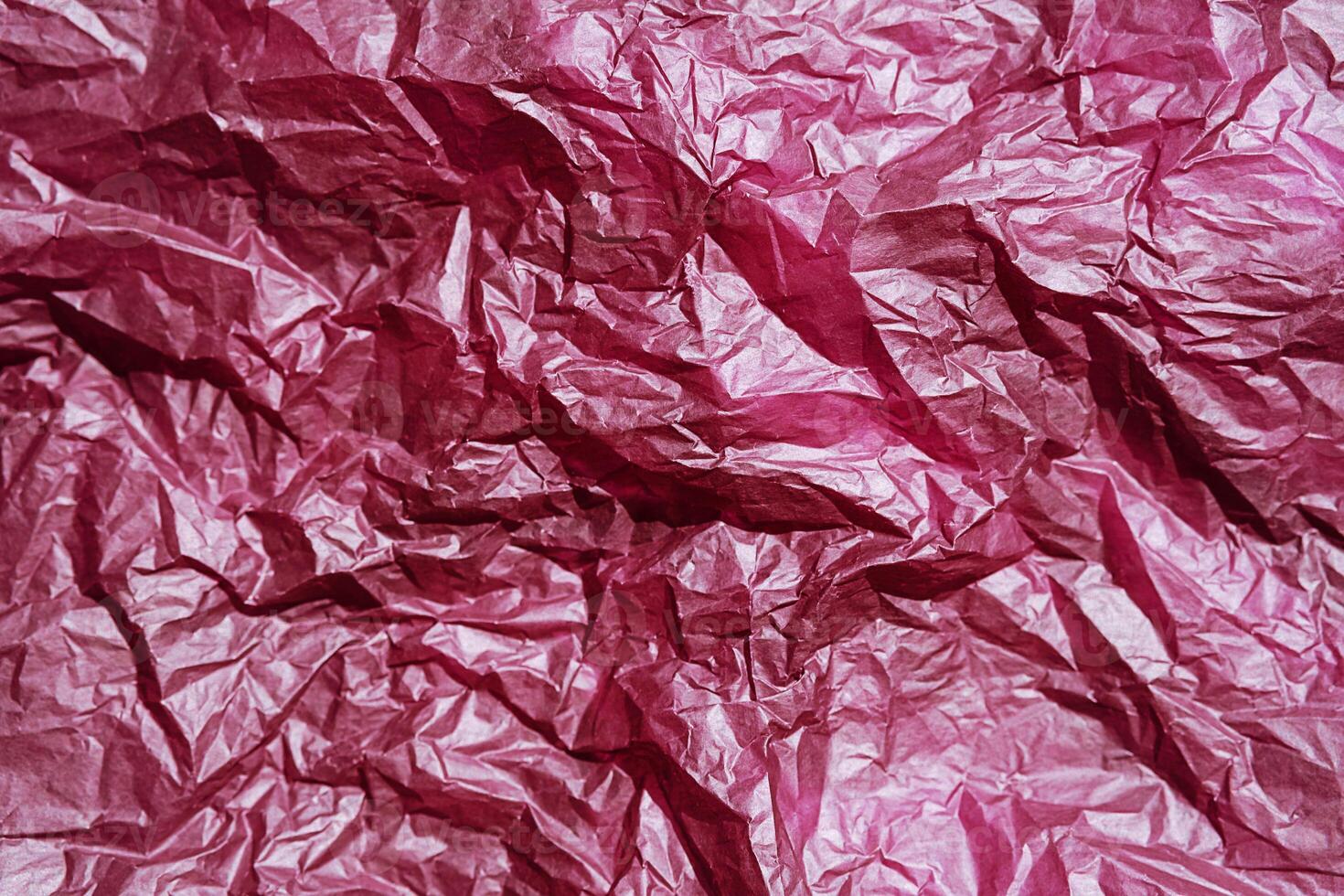 Close up of crumpled pink paper showing detailed texture. photo