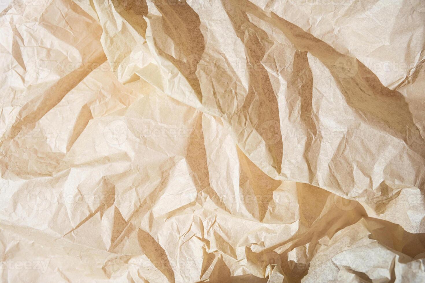 Crumpled beige paper texture with folds and creases. photo