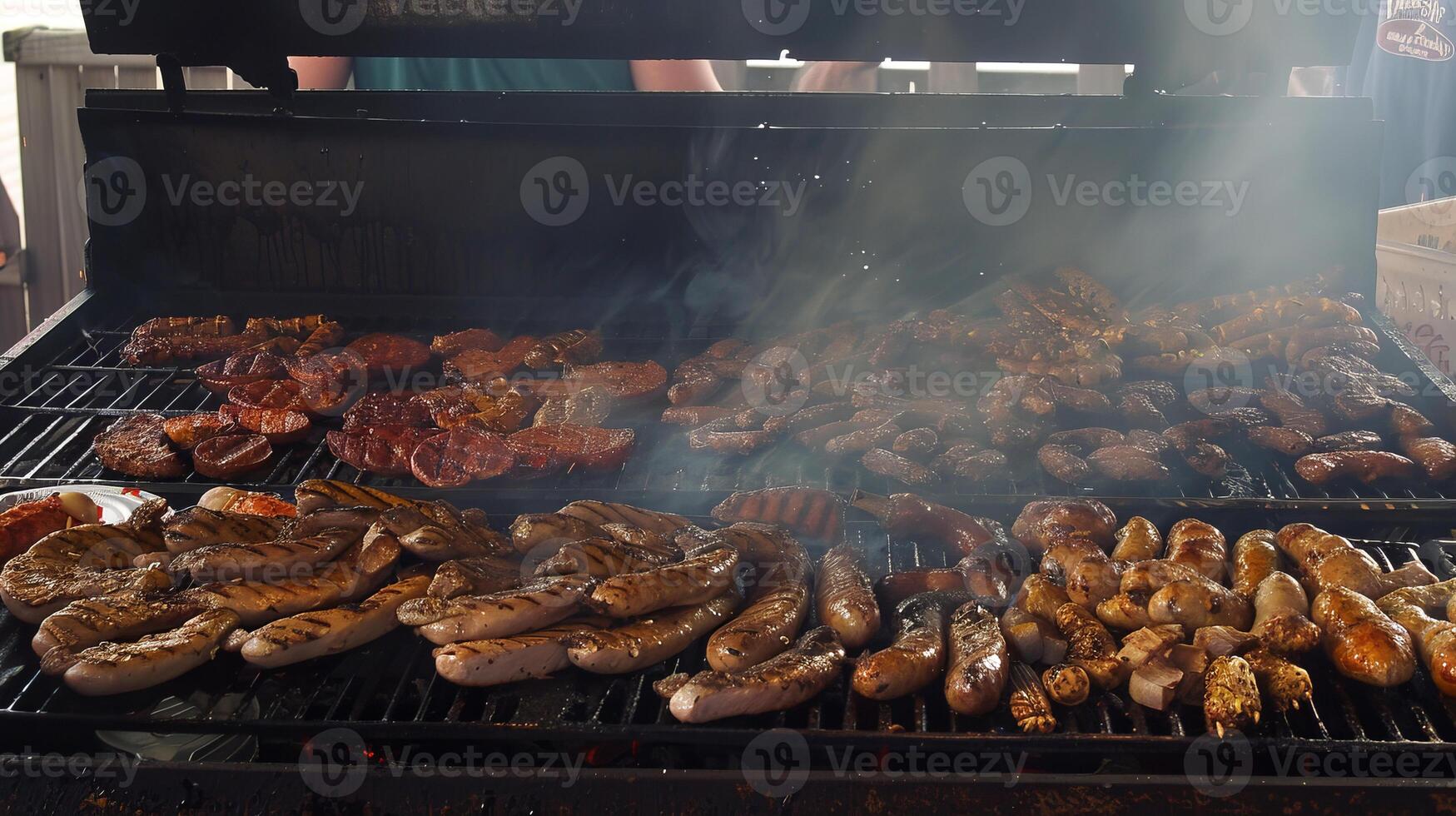 Assorted sausages and meats grilling on a barbecue with smoke rising photo