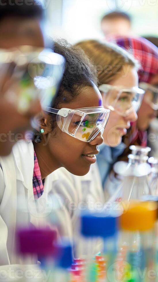 Diverse group of students conducting a chemistry experiment in a laboratory wearing safety goggles photo