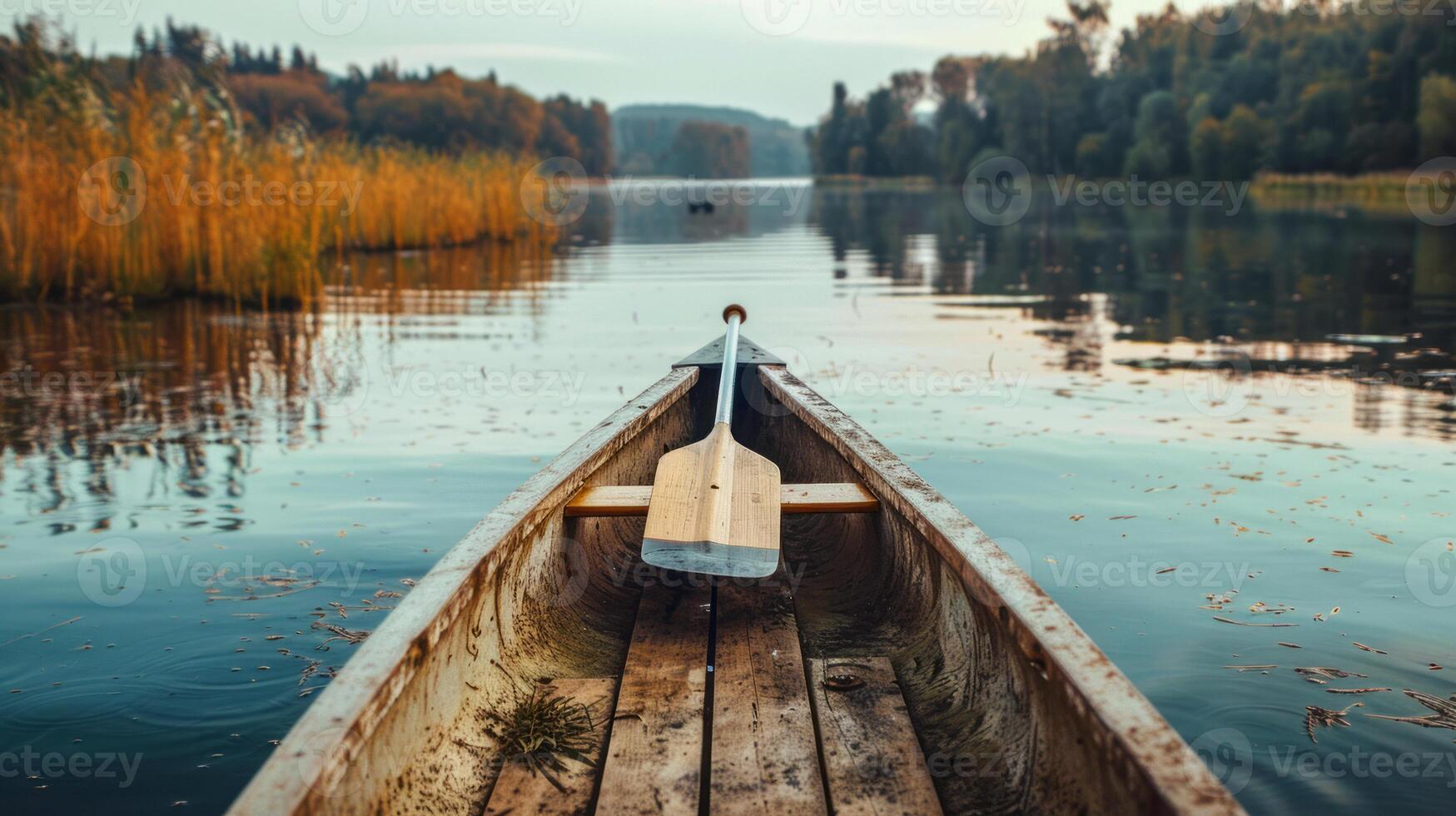 Serene Canoe Ride on a Calm Lake with Autumn Foliage in the Background photo