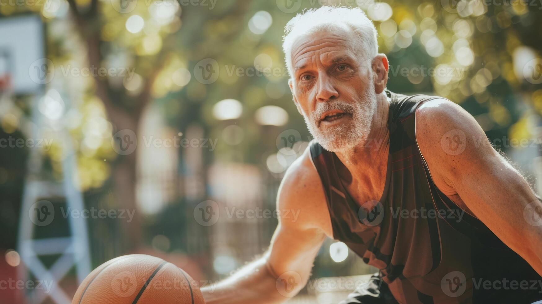 Elderly man playing basketball with enthusiasm on urban court photo