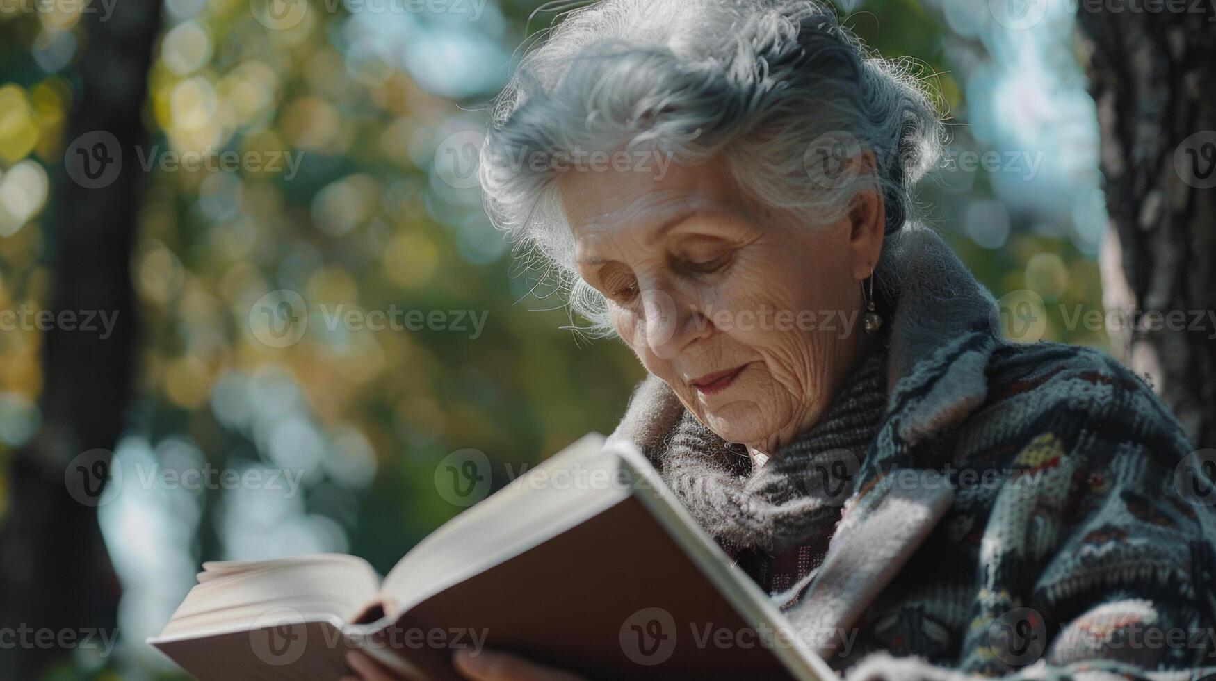 Senior woman enjoying a book in autumn forest photo