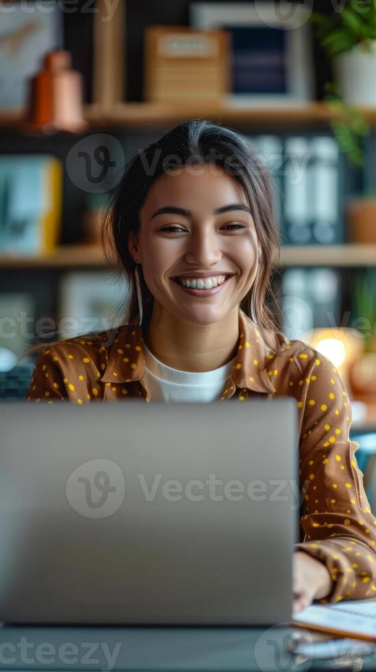 Happy young woman working at a laptop photo