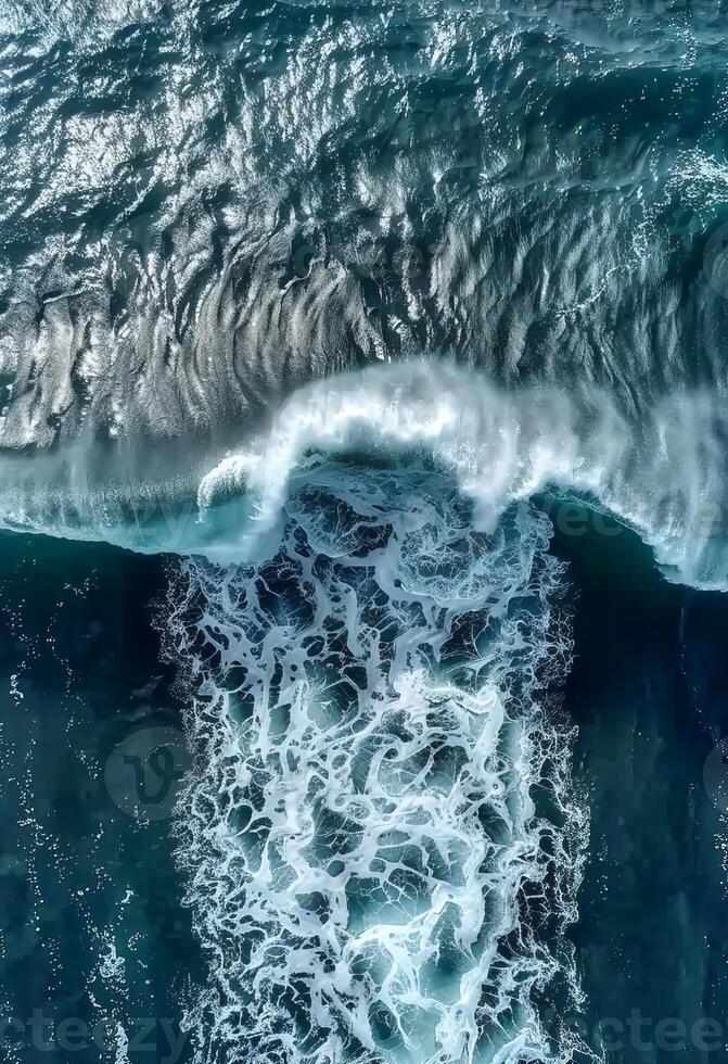 Aerial view of ocean waves crashing on a sandy beach photo