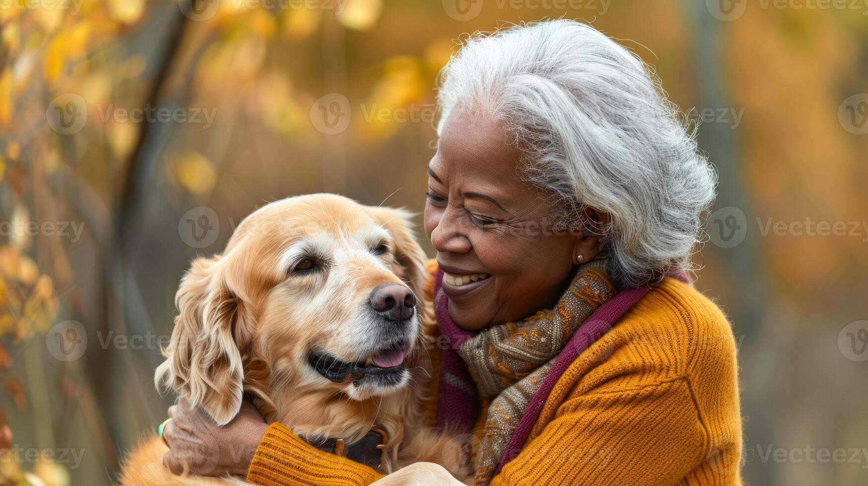 Happy senior woman embracing her dog outdoors in fall photo