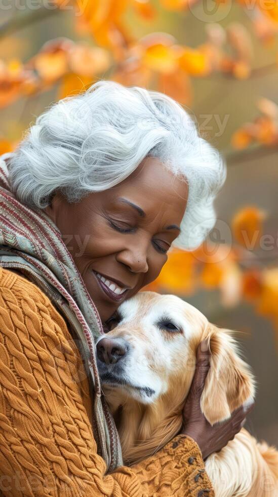 Elderly woman in autumn park with her beloved golden retriever photo