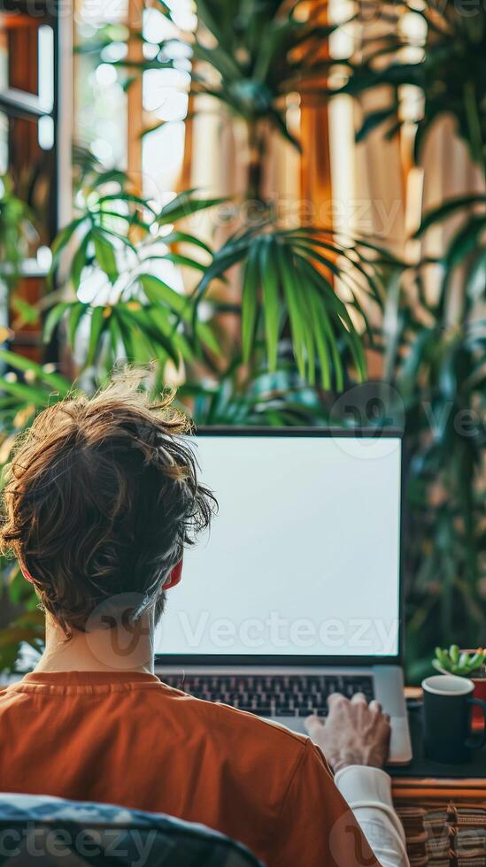 Home Office with Green Plants and Man at Laptop photo
