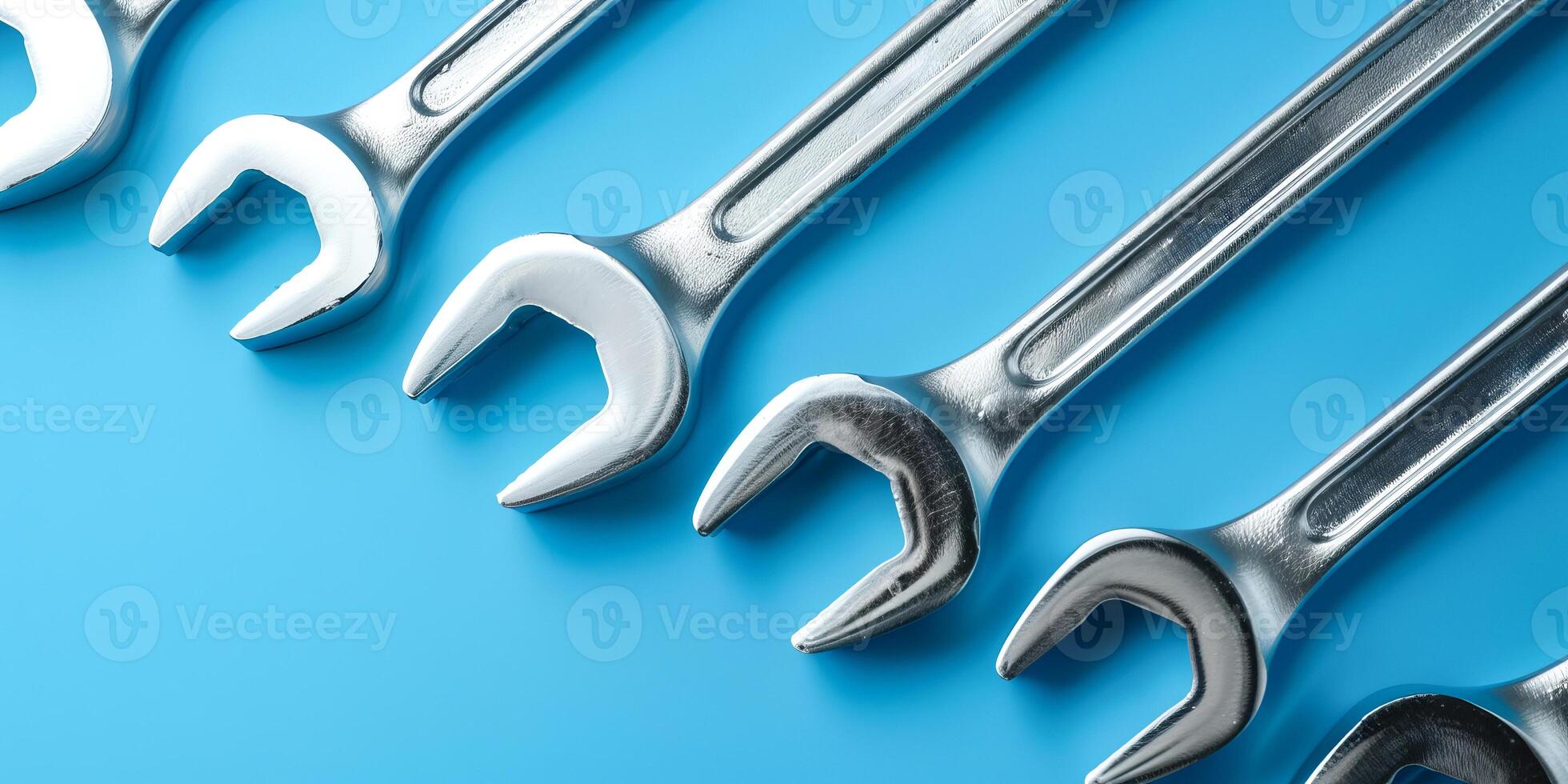 Neatly arranged spanners on blue background photo
