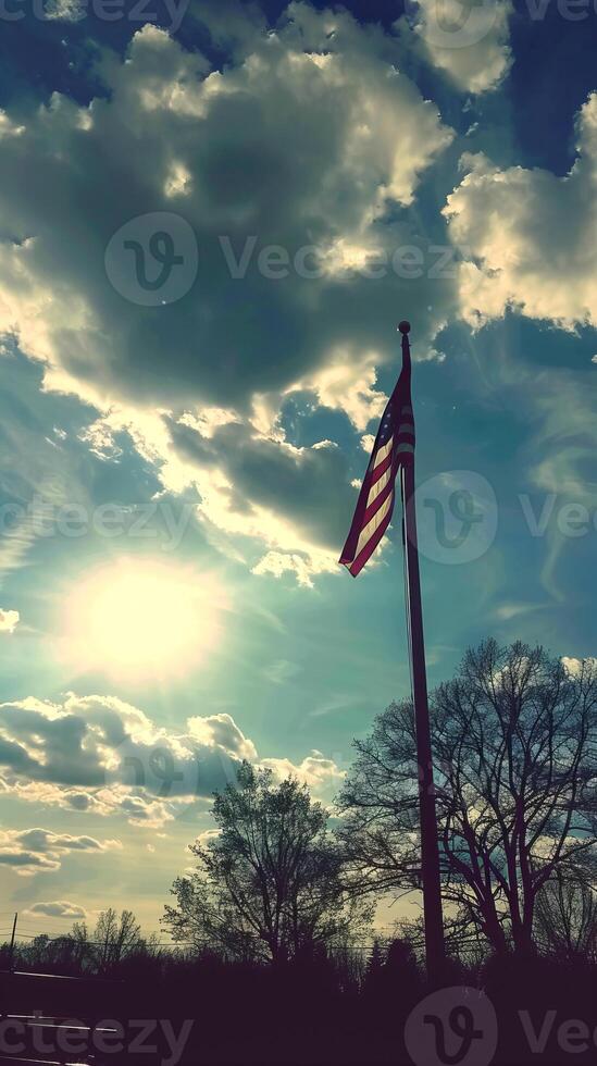 American Flag Waving Against Bright Sky and Clouds photo