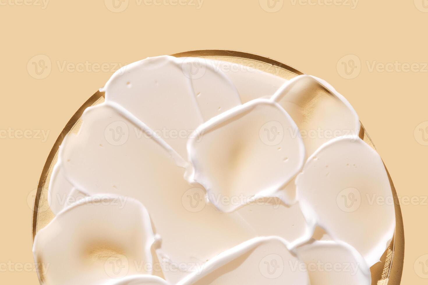 A smear of white cream on a beige background on a round stand. photo